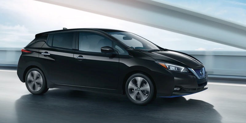 Black Nissan Leaf driving with motion blur.