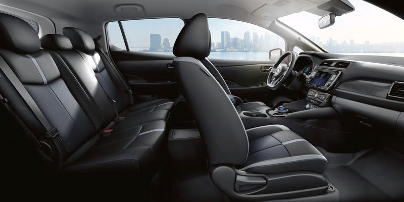 Interior view of Nissan Leaf with cityscape visible.