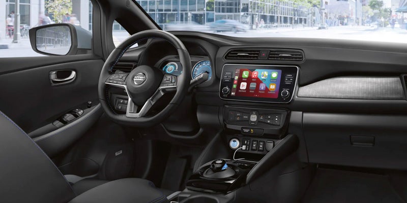 Modern car interior with front seats and touchscreen display.